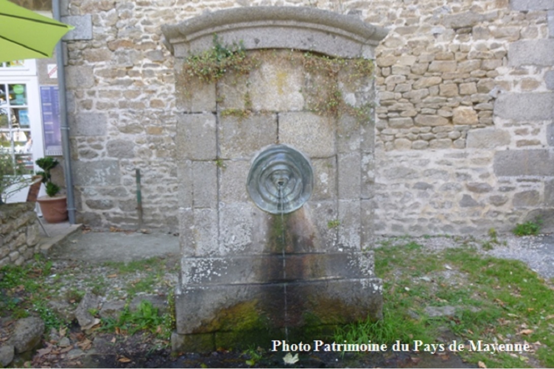 Ces têtes qui vous observent - Saint-Georges-Buttavent, Fontaine du bourg de Fontaine-Daniel